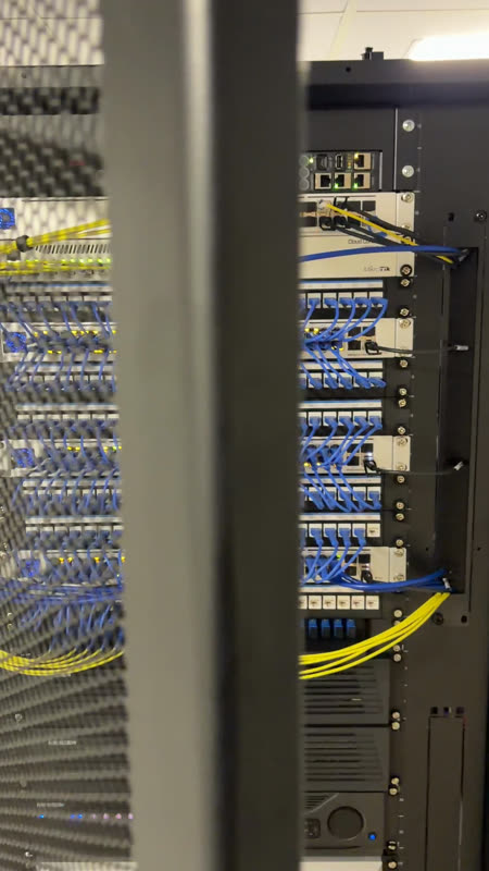 Pasillo de racks con distribución óptica estructurada.