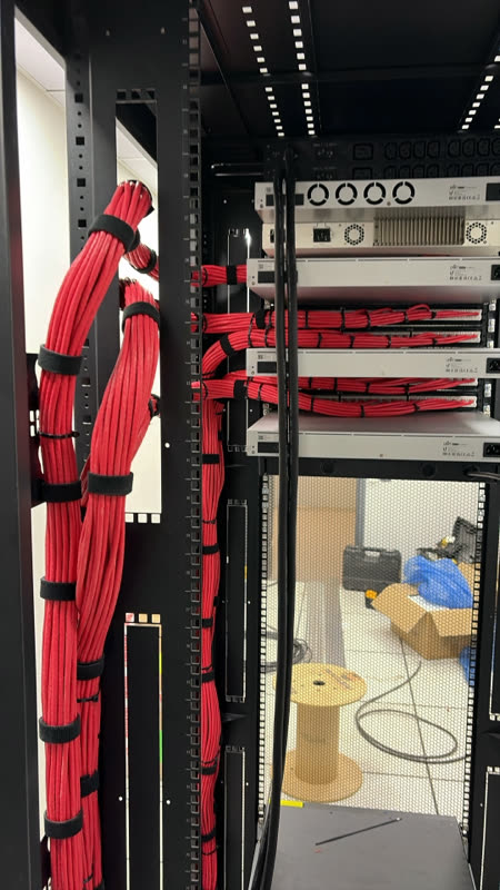 Guías verticales y amarre de cables de fuerza en rack de data center.
